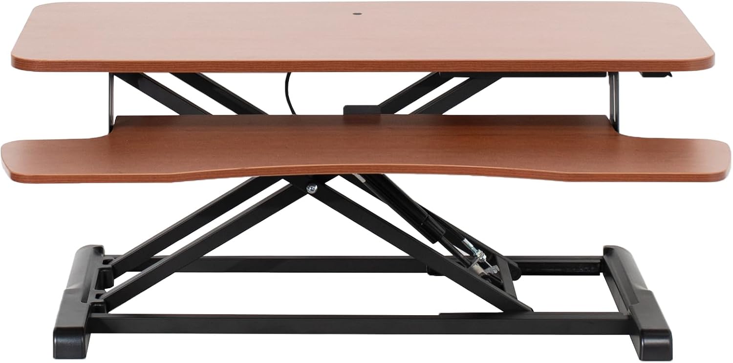 Black standing desk converter shown raised to standing height with keyboard tray extended