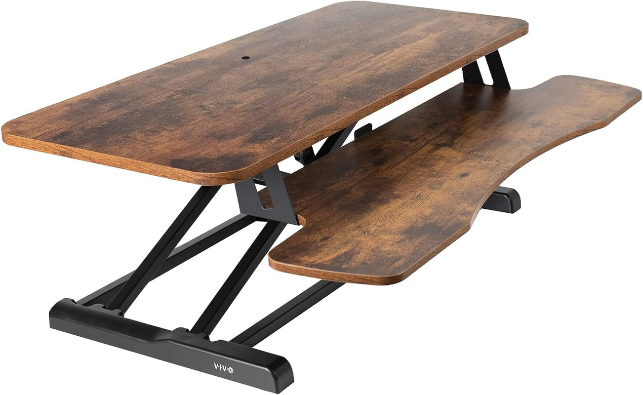 Black standing desk converter shown raised to standing height with keyboard tray extended