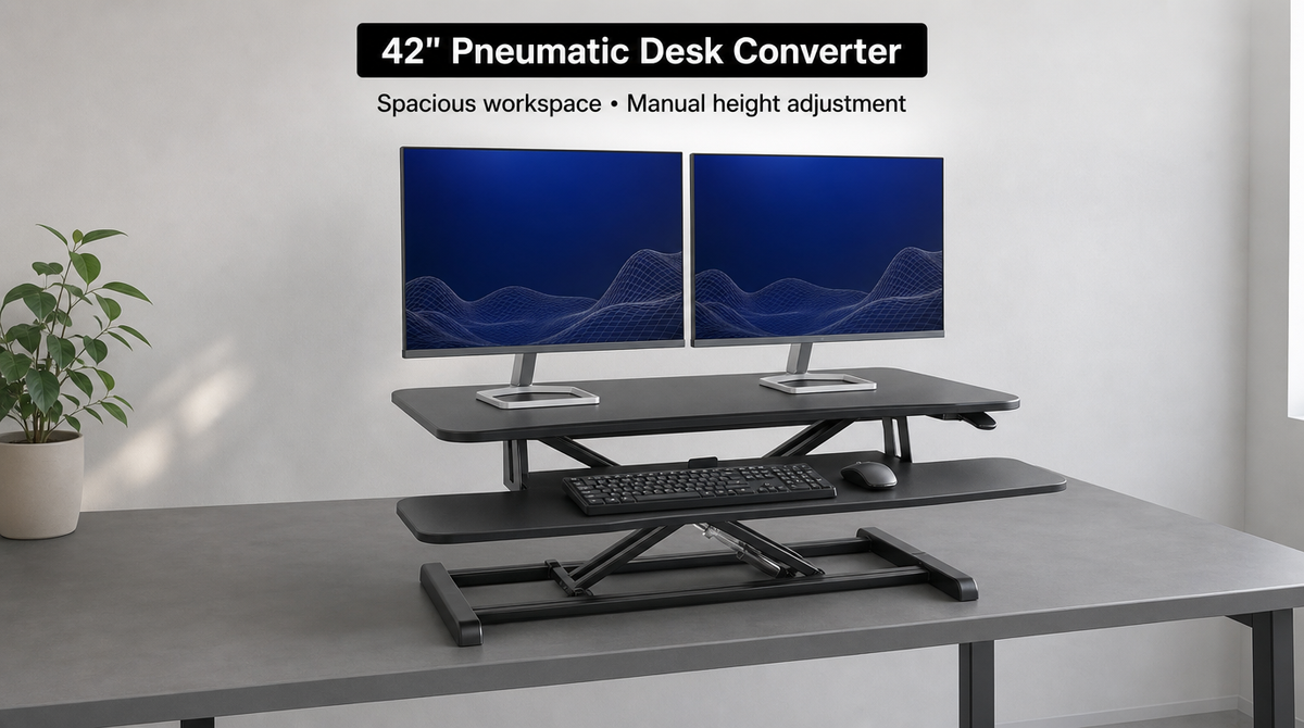 “42-inch pneumatic standing desk converter with dual monitors and a wide tray holding a keyboard and mouse.”