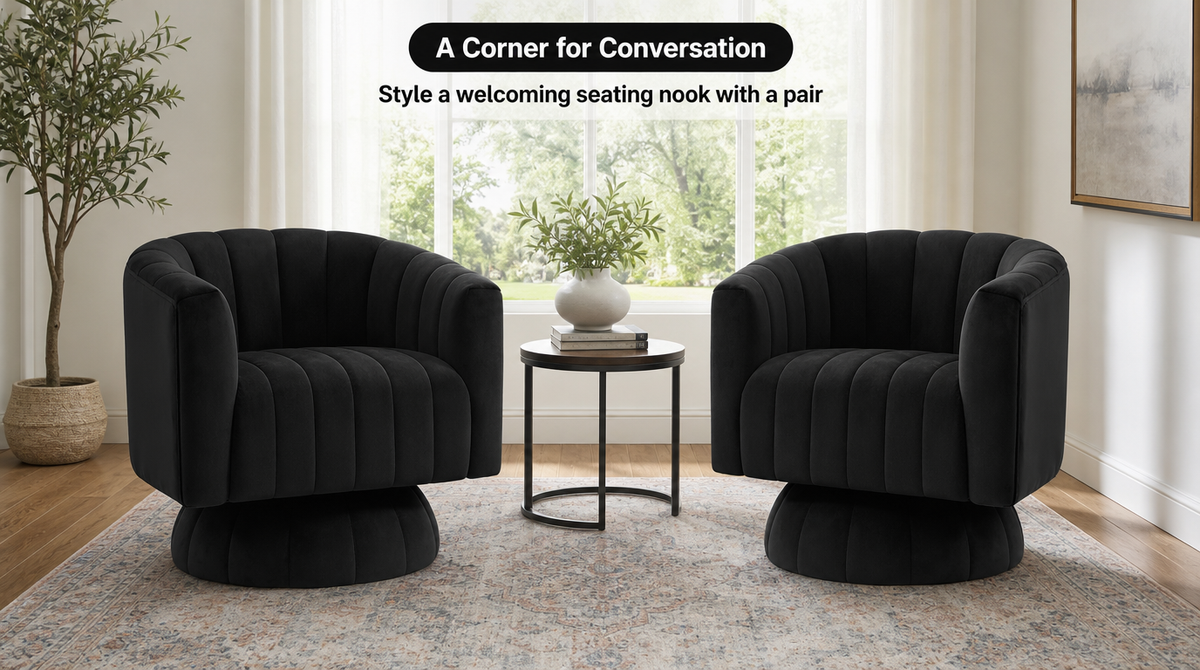 “Two black velvet barrel chairs arranged around a small side table in a bright living room.”
