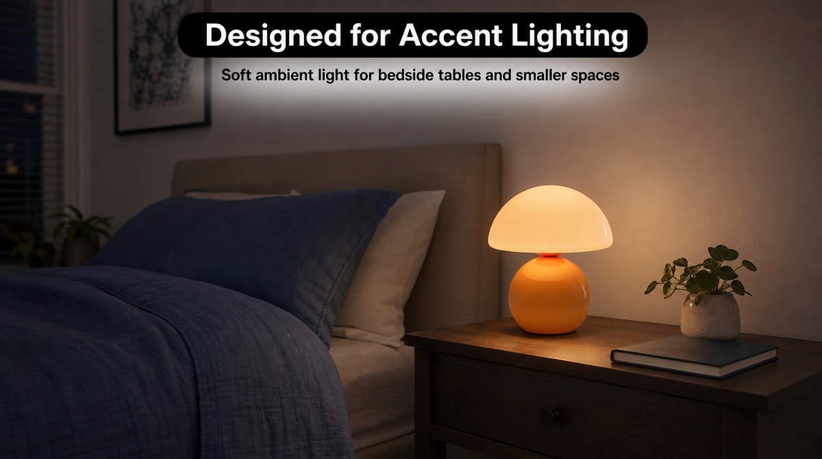 “Orange mushroom lamp providing a pool of soft accent light on a nightstand in an otherwise dim bedroom.”