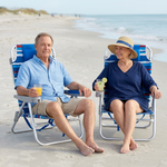 Two people relaxing in matching light blue stripe backpack beach chairs on the sand, each reclined with a drink in hand and the ocean in the background