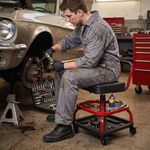 Mechanic seated on the yellow rolling stool performing a front brake job in a home garage