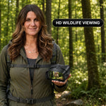 Woman using high-powered binoculars to view a mountain landscape at sunset