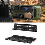 Two-tier tailgate table mounted on a vehicle rear door holding fuel cans and camp gear
