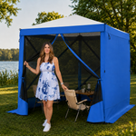 Brown pop-up screen gazebo at a forest lakeside campsite with two people seated at a table inside