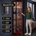 Person arranging décor inside the open glass door of the tall oak corner curio cabinet