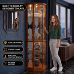 Person arranging décor inside the open glass door of the tall oak corner curio cabinet