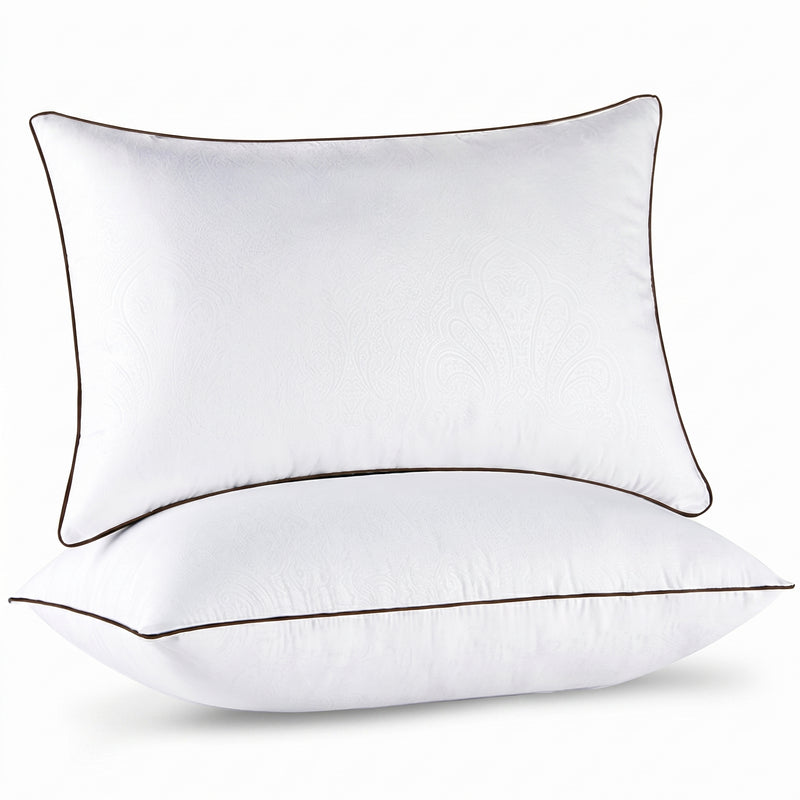 Two down alternative pillows with brown piping and a subtle damask pattern, stacked on a white background