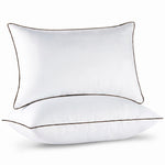Two down alternative pillows with brown piping and a subtle damask pattern, stacked on a white background