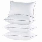 Two down alternative pillows with brown piping and a subtle damask pattern, stacked on a white background