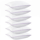 Two down alternative pillows with brown piping and a subtle damask pattern, stacked on a white background