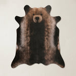Faux cowhide rug in cow print styled under a leather sofa in a modern living room