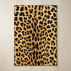 Faux cowhide rug in cow print styled under a leather sofa in a modern living room