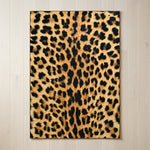 Faux cowhide rug in cow print styled under a leather sofa in a modern living room