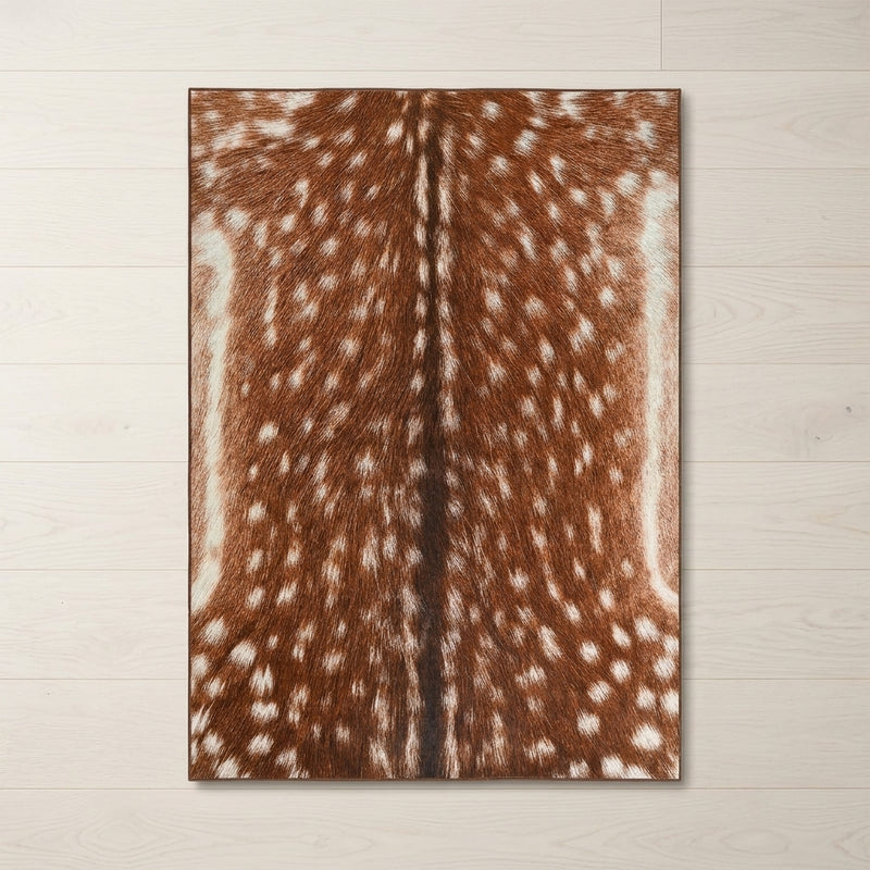 Faux cowhide rug in cow print styled under a leather sofa in a modern living room