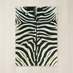 Faux cowhide rug in cow print styled under a leather sofa in a modern living room