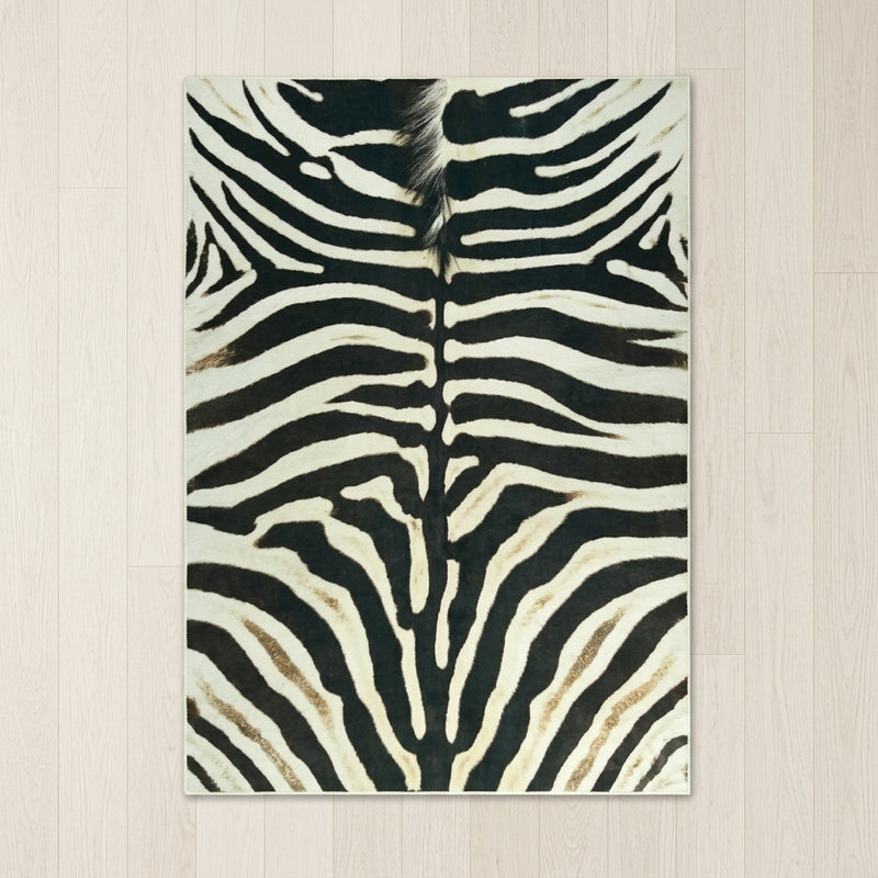 Faux cowhide rug in cow print styled under a leather sofa in a modern living room