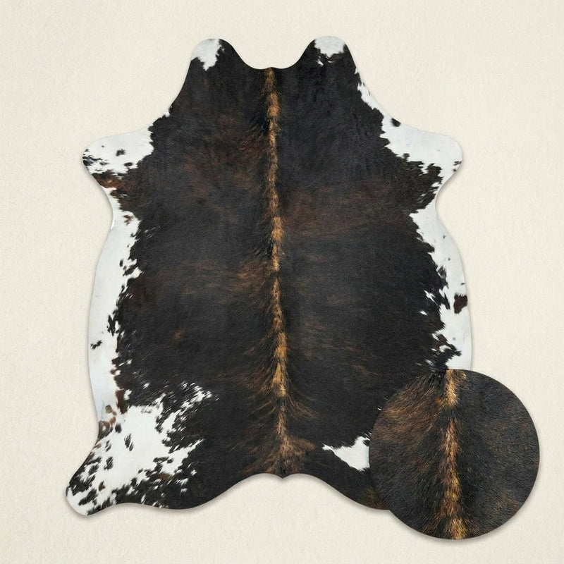 Faux cowhide rug in cow print styled under a leather sofa in a modern living room