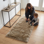 Grey faux fur runner rug styled in an entryway beside a console table on hardwood flooring