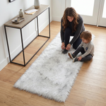 Grey faux fur runner rug styled in an entryway beside a console table on hardwood flooring