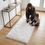 Grey faux fur runner rug styled in an entryway beside a console table on hardwood flooring