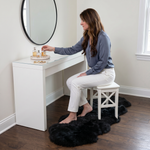 Grey faux fur runner rug styled in an entryway beside a console table on hardwood flooring