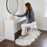 Grey faux fur runner rug styled in an entryway beside a console table on hardwood flooring