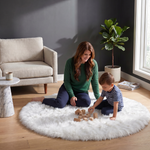 Grey faux fur runner rug styled in an entryway beside a console table on hardwood flooring