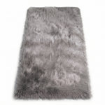 Close-up of grey faux fur area rug showing thick high-pile shaggy texture