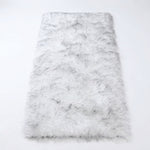 Close-up of grey faux fur area rug showing thick high-pile shaggy texture