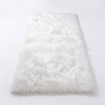 Close-up of grey faux fur area rug showing thick high-pile shaggy texture