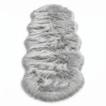 Close-up of grey faux fur area rug showing thick high-pile shaggy texture