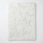 Close-up of grey faux fur area rug showing thick high-pile shaggy texture