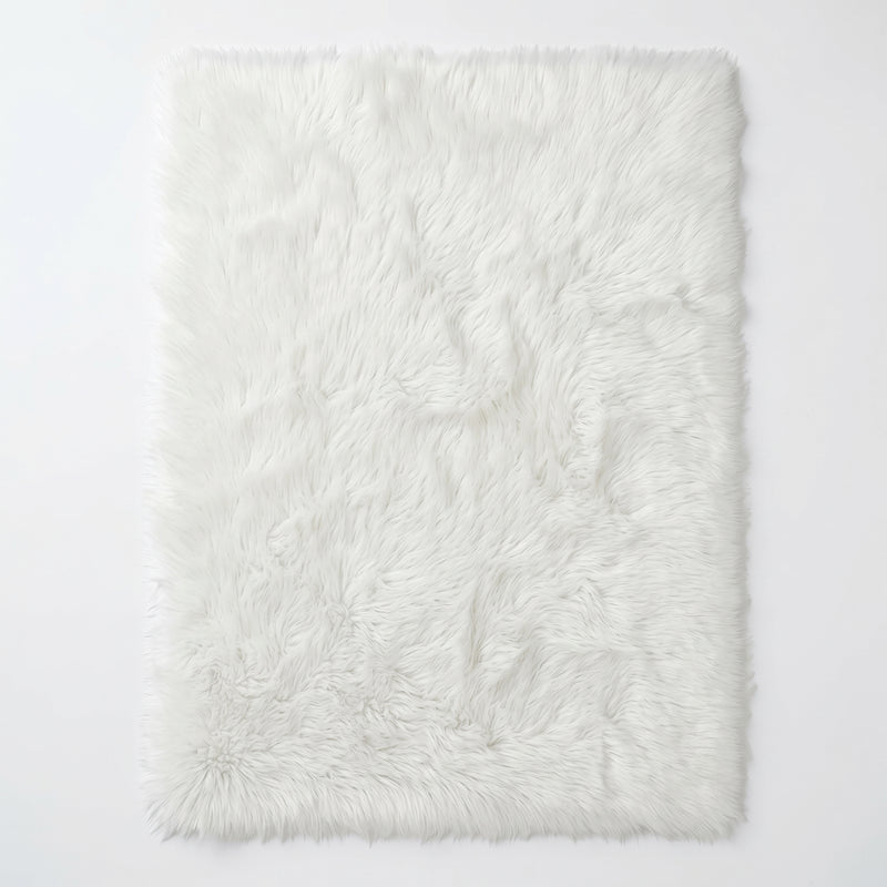 Close-up of grey faux fur area rug showing thick high-pile shaggy texture