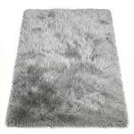 Close-up of grey faux fur area rug showing thick high-pile shaggy texture