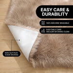 Faux fur area rug shown beside a bed, illustrating machine-washable, vacuum-or-shake-clean maintenance