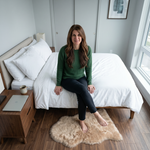 Faux fur sheepskin rug on a closet floor with a woman standing barefoot while reaching for a hanger