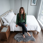 Faux fur sheepskin rug on a closet floor with a woman standing barefoot while reaching for a hanger