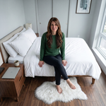 Faux fur sheepskin rug on a closet floor with a woman standing barefoot while reaching for a hanger