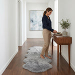 Faux fur sheepskin rug on a closet floor with a woman standing barefoot while reaching for a hanger