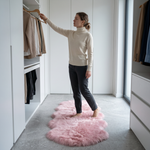 Faux fur sheepskin rug on a closet floor with a woman standing barefoot while reaching for a hanger