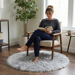 Faux fur sheepskin rug on a closet floor with a woman standing barefoot while reaching for a hanger