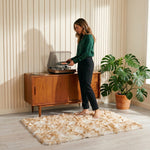 Faux fur sheepskin rug on a closet floor with a woman standing barefoot while reaching for a hanger