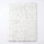 Faux fur sheepskin rug in white and yellow, shown flat from above in its natural pelt shape