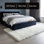 White fluffy faux sheepskin rug in bedroom beside bed — bedside rug placement