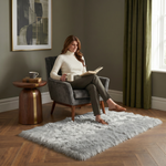 Ultra-soft faux sheepskin area rug in white placed in living room beside armchair