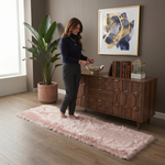 Ultra-soft faux sheepskin area rug in white placed in living room beside armchair