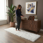 Ultra-soft faux sheepskin area rug in white placed in living room beside armchair