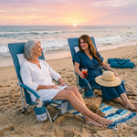 Woman relaxing in a low folding beach chair at the beach